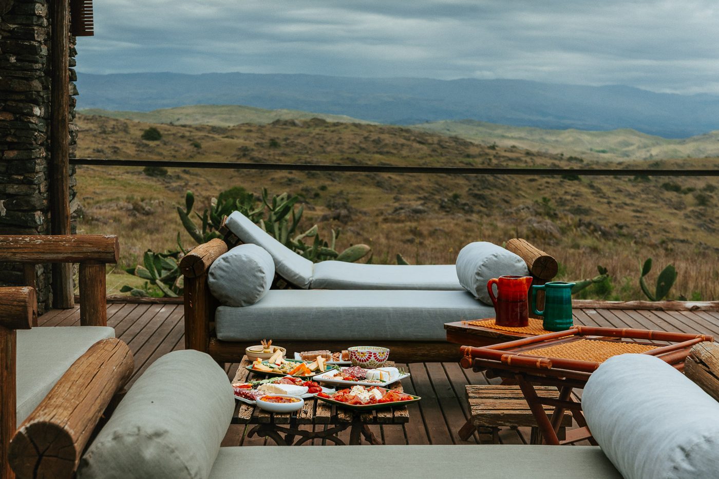 The daybeds on the deck, the hills behind