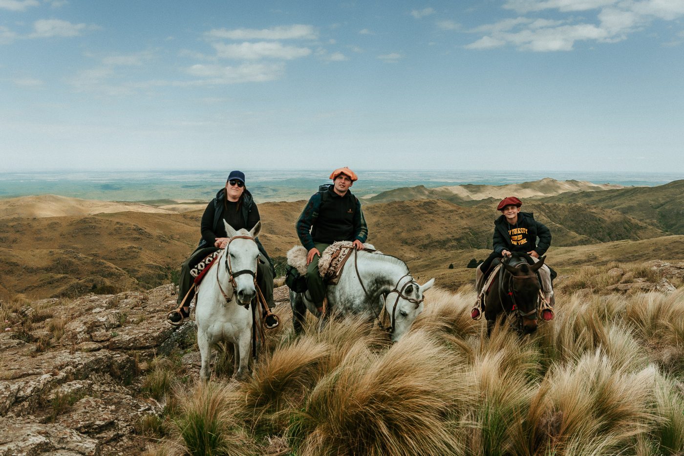Tres jinetes en la cumbre, con las sierras detrás
